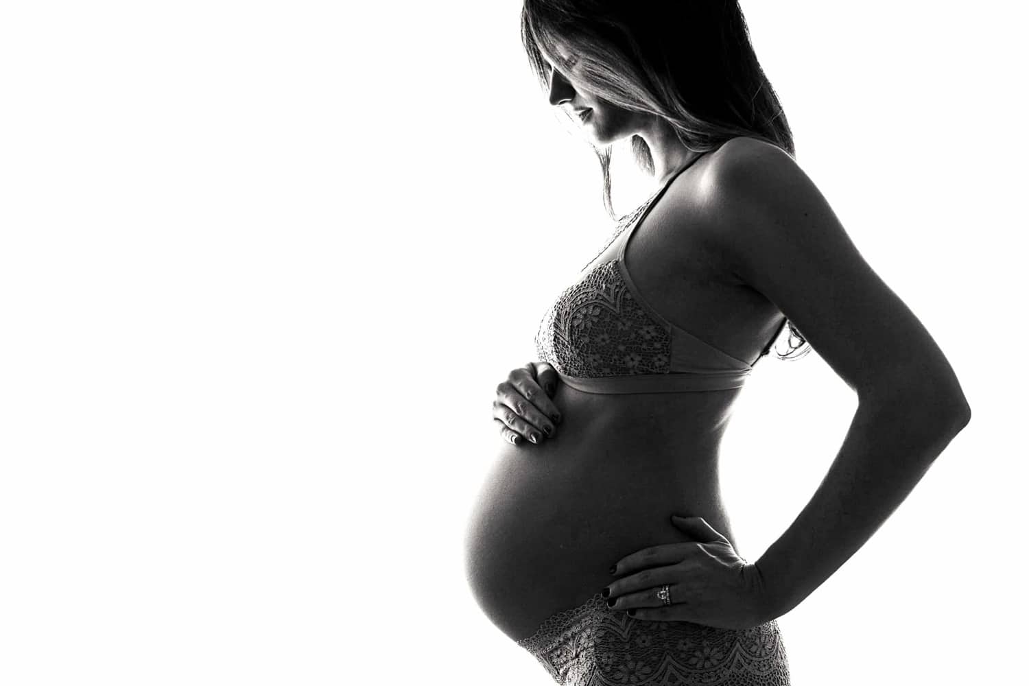 A black & white maternity photo of a woman in lace.