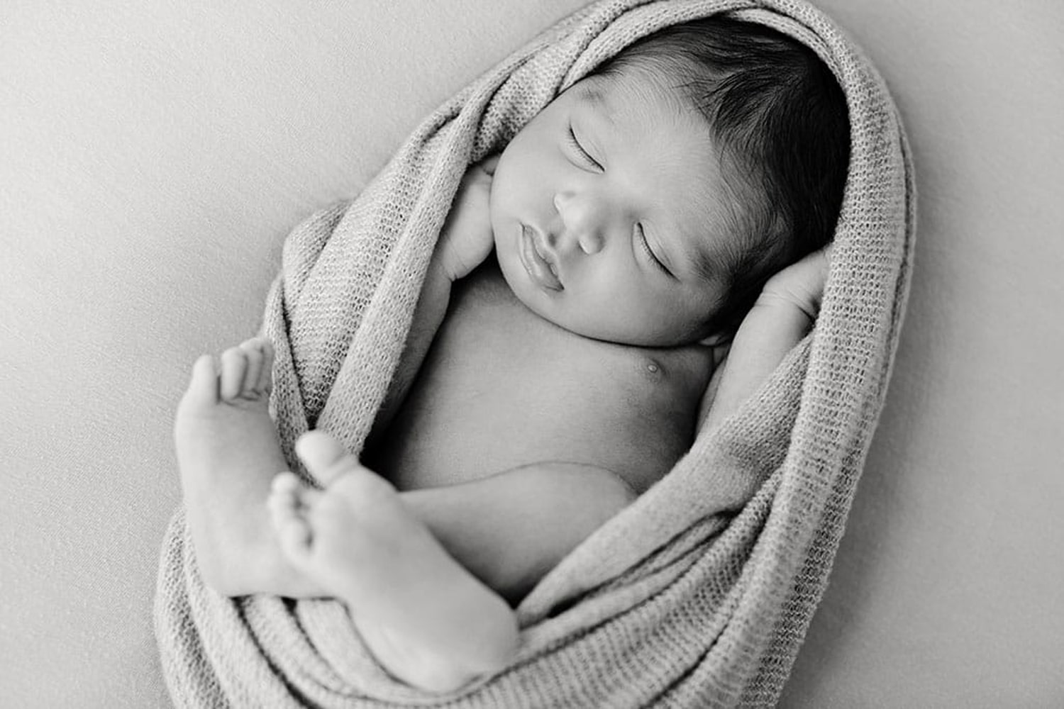 A baby is wrapped in a swaddle.