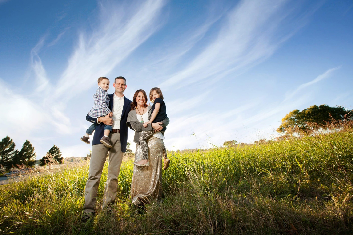 A family of four takes photos outside.