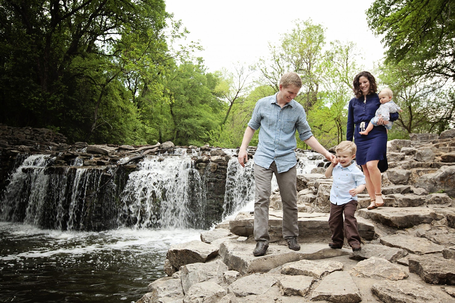 A family of four takes photos outside.