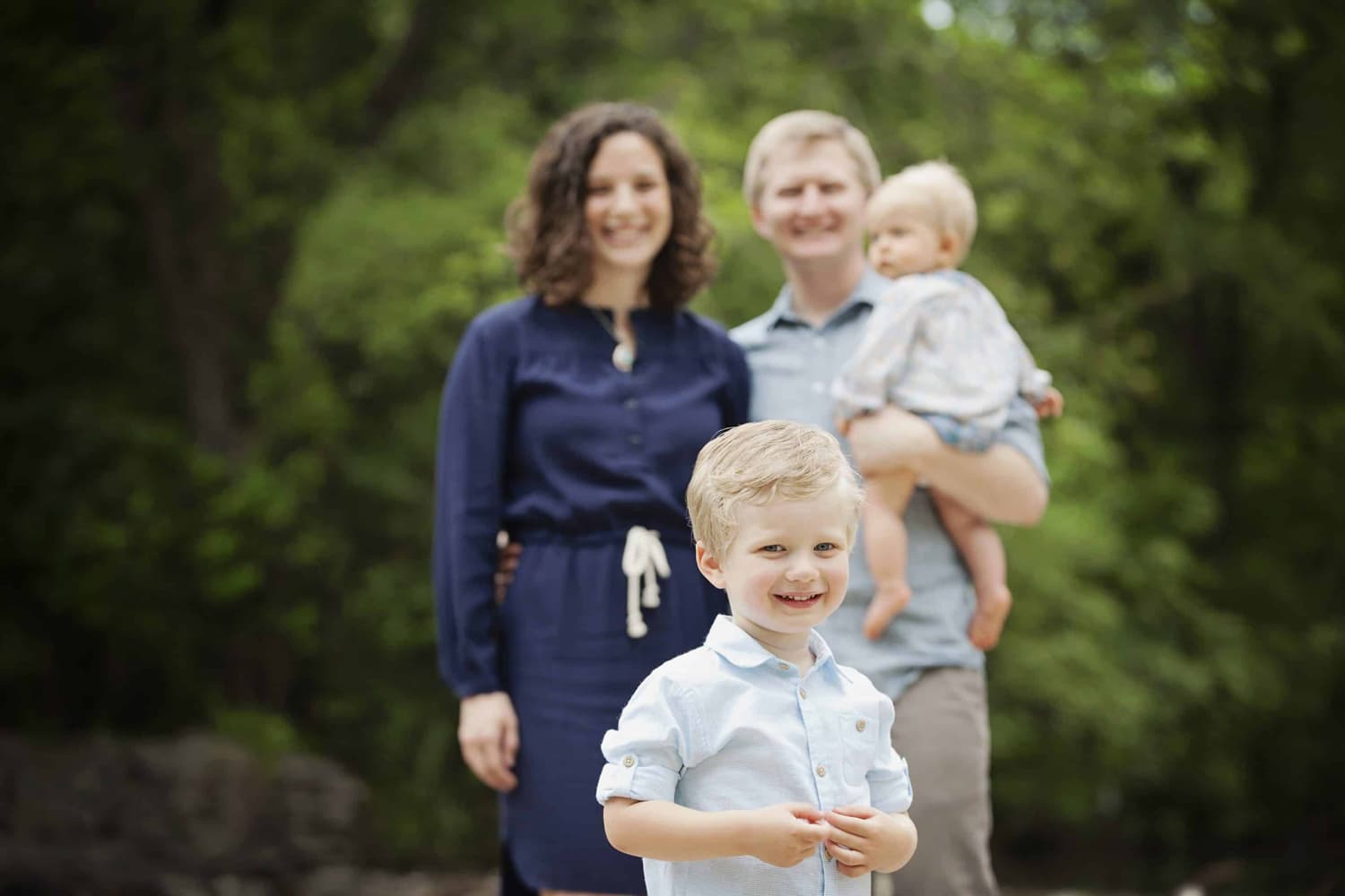 A family of four takes photos outside.