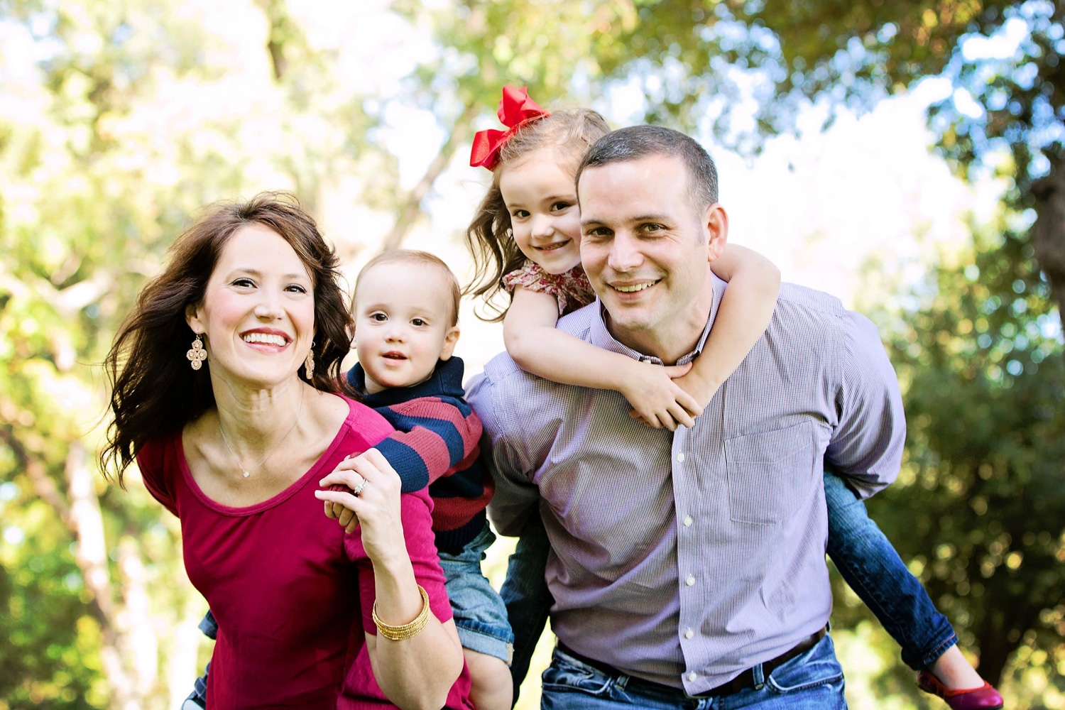 A family of four takes photos outside.