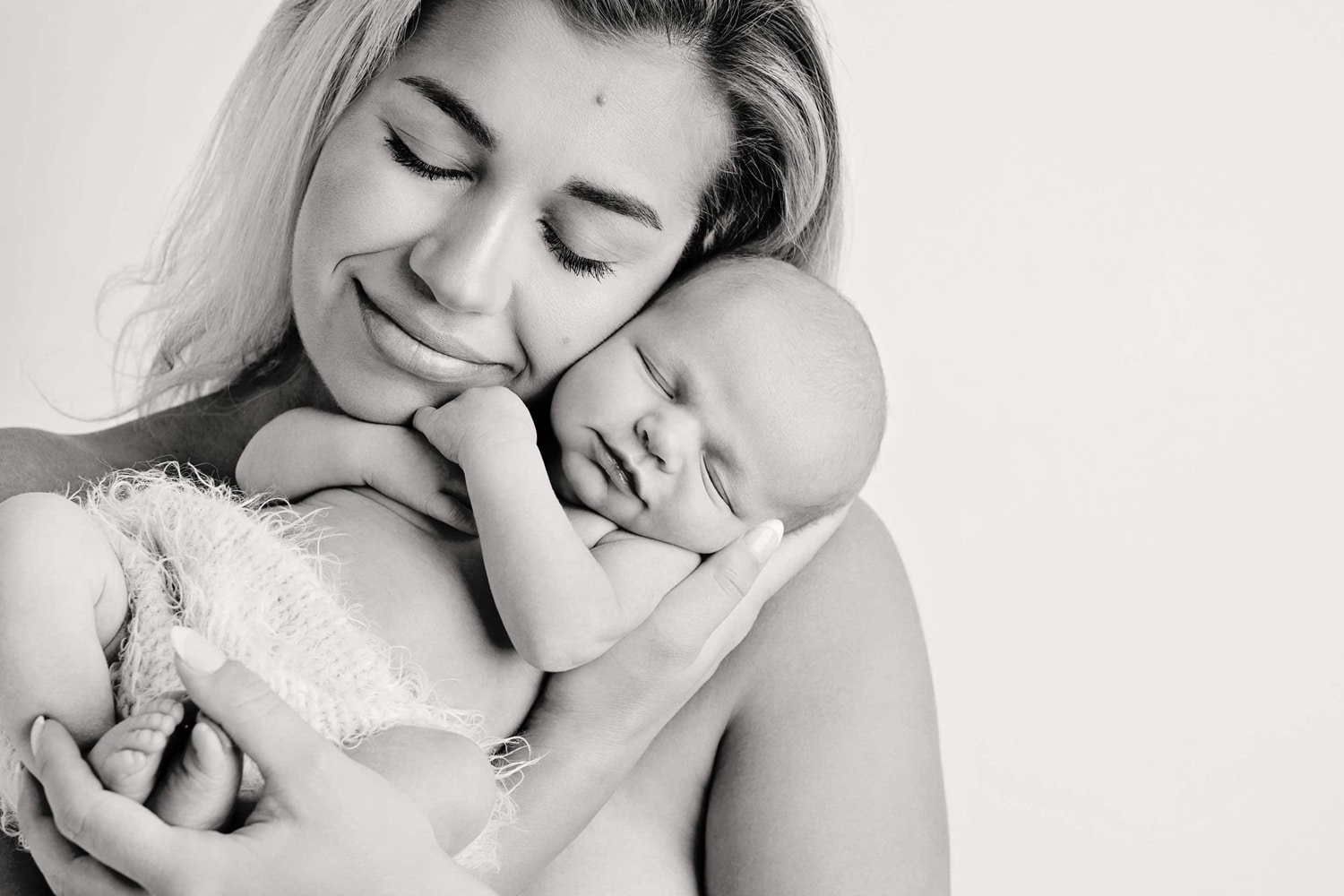 A woman cradles her newborn baby.