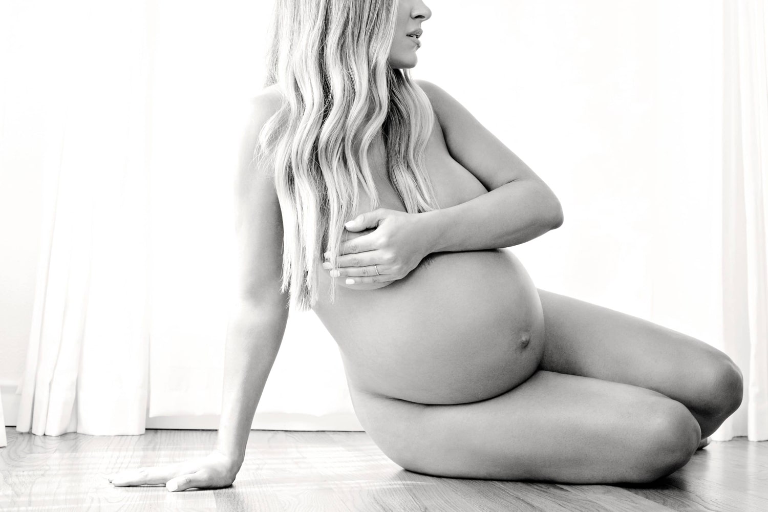 A pregnant woman takes maternity photos.