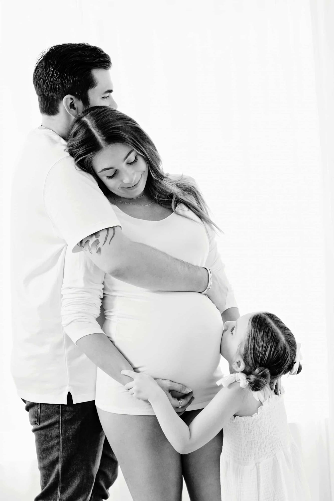 A family poses for a maternity photo.