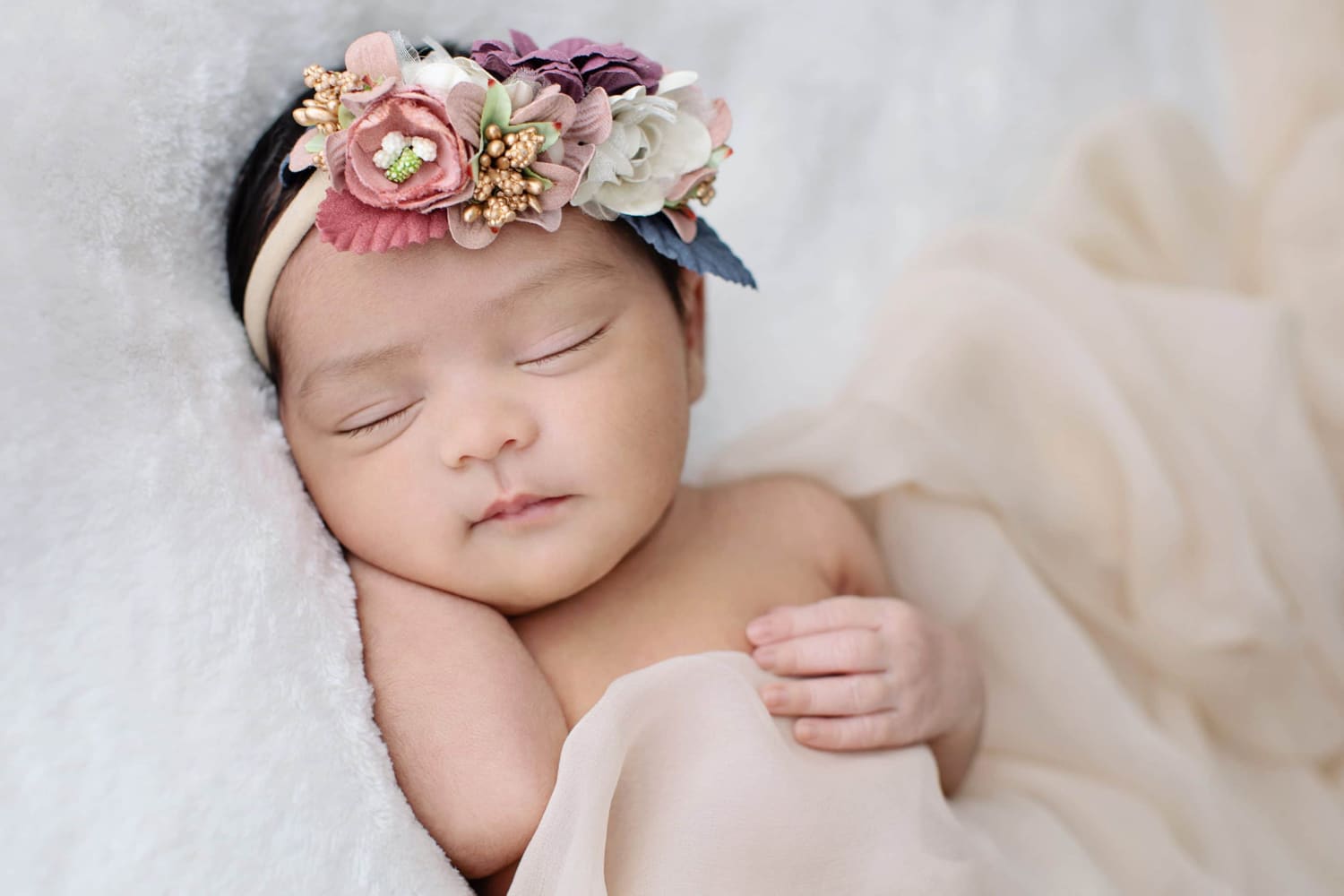 A newborn baby with a flower headband.