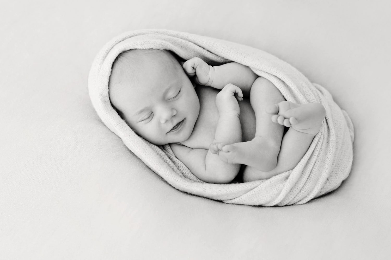 A newborn baby wrapped in a swaddle.