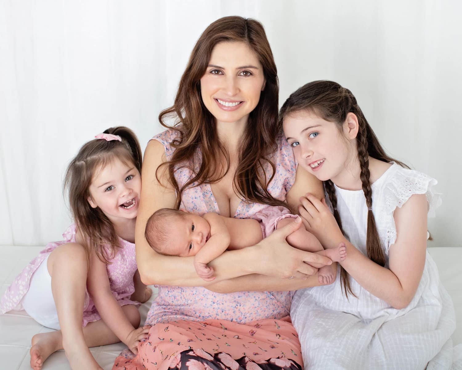 A mom and her three daughters take a photo.