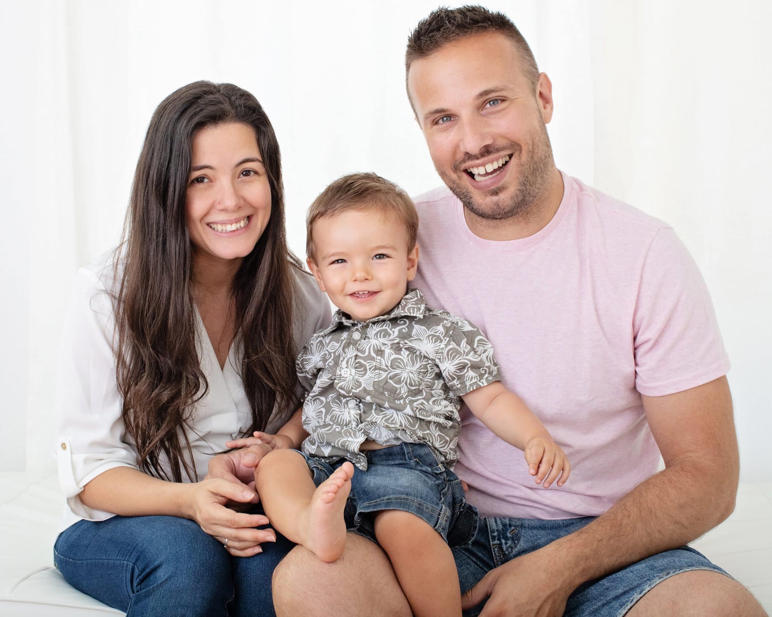 Two parents and their son take a photo.