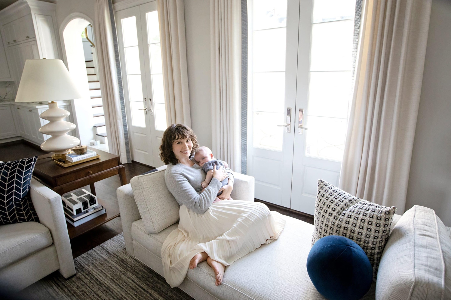 A mom and her three month old baby at home.
