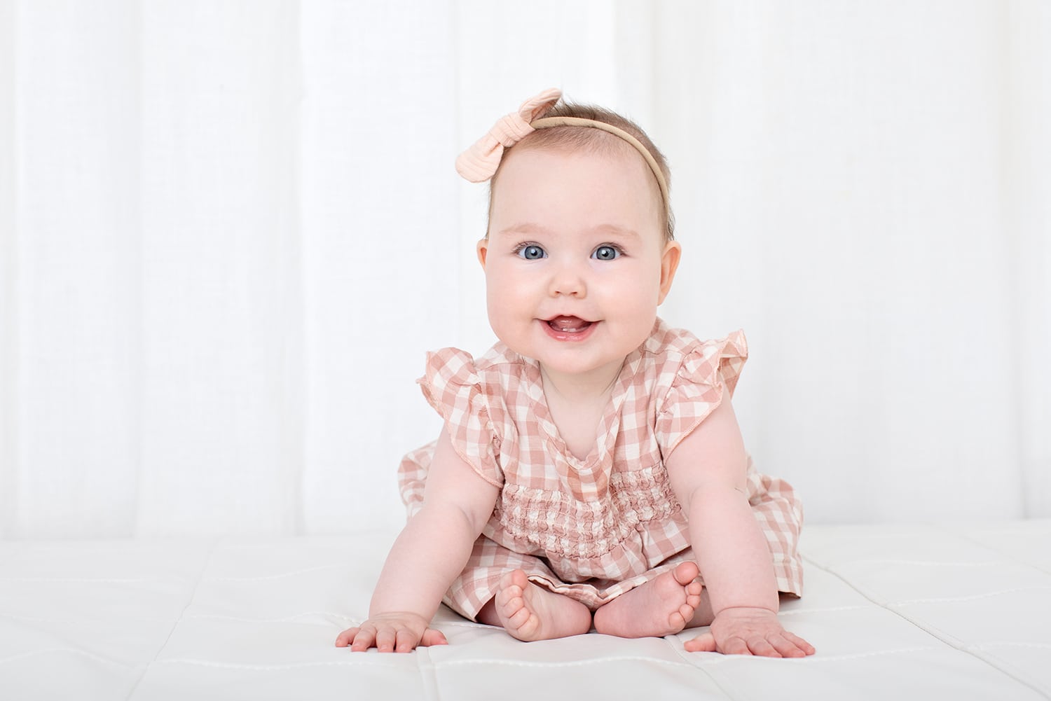 A six month old sits up on her own.