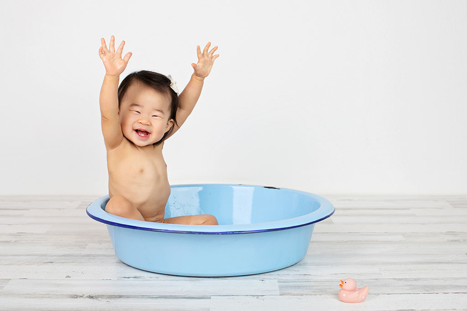 A baby celebrates in a bathtub.