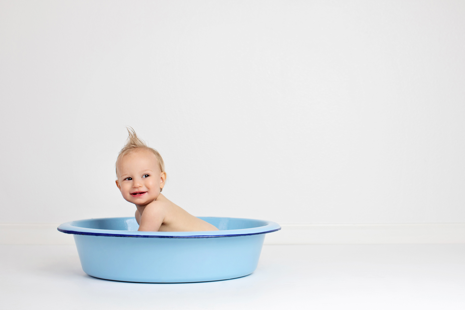 A one year old takes a bath.