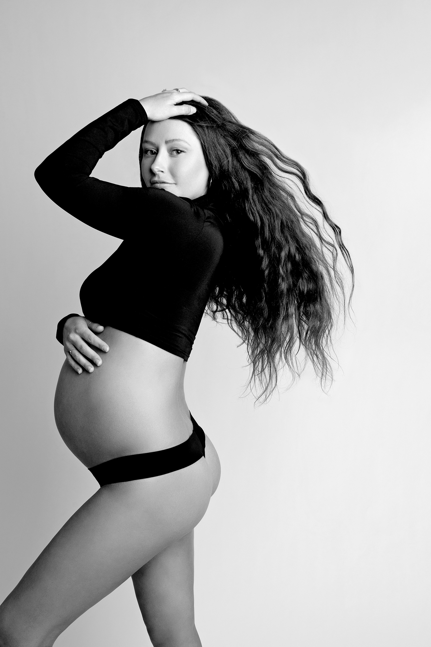 Maternity photo of a mom in a black crop top.