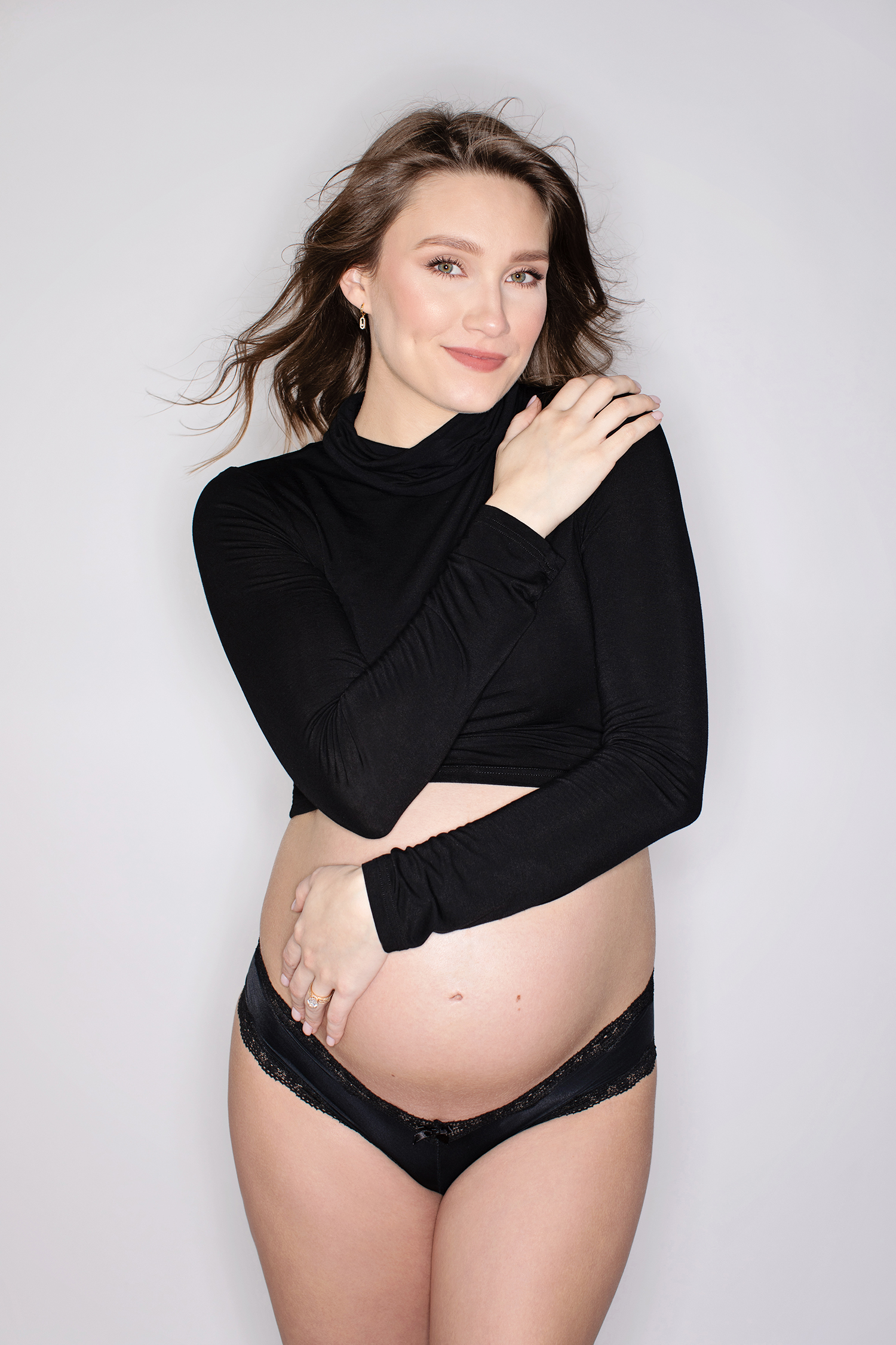 A smiling pregnant woman in a black top.