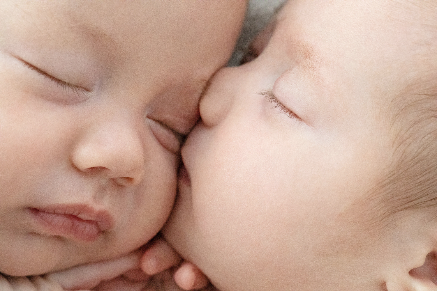 A newborn kisses their sibling.
