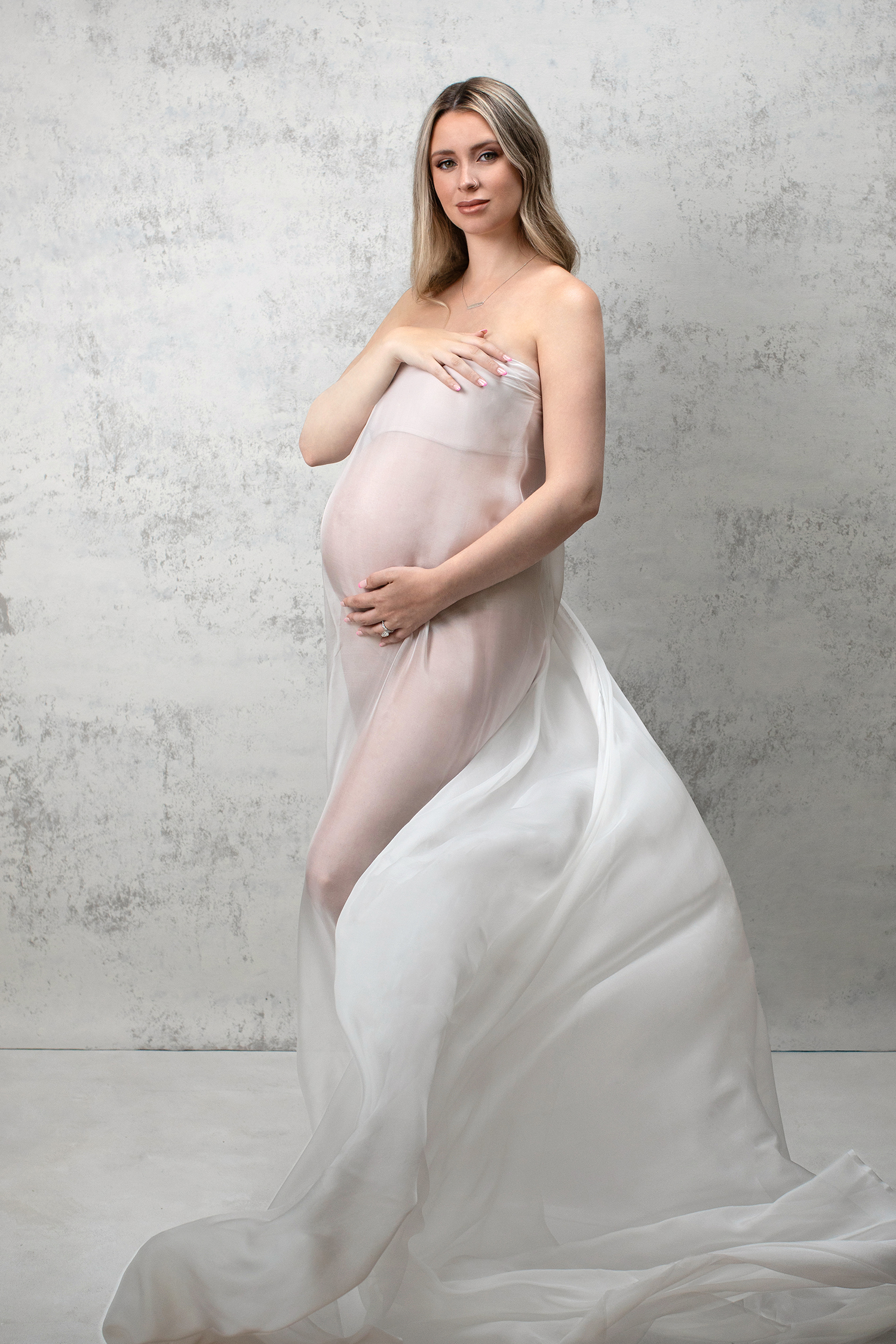 A portrayal of an expectant mother showcasing her elegance and sophistication in a luxurious maternity photography session.