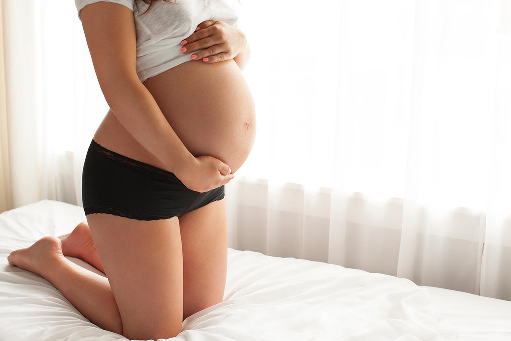 a pregnant woman posing in casual loungewear, for a natural maternity photoshoot