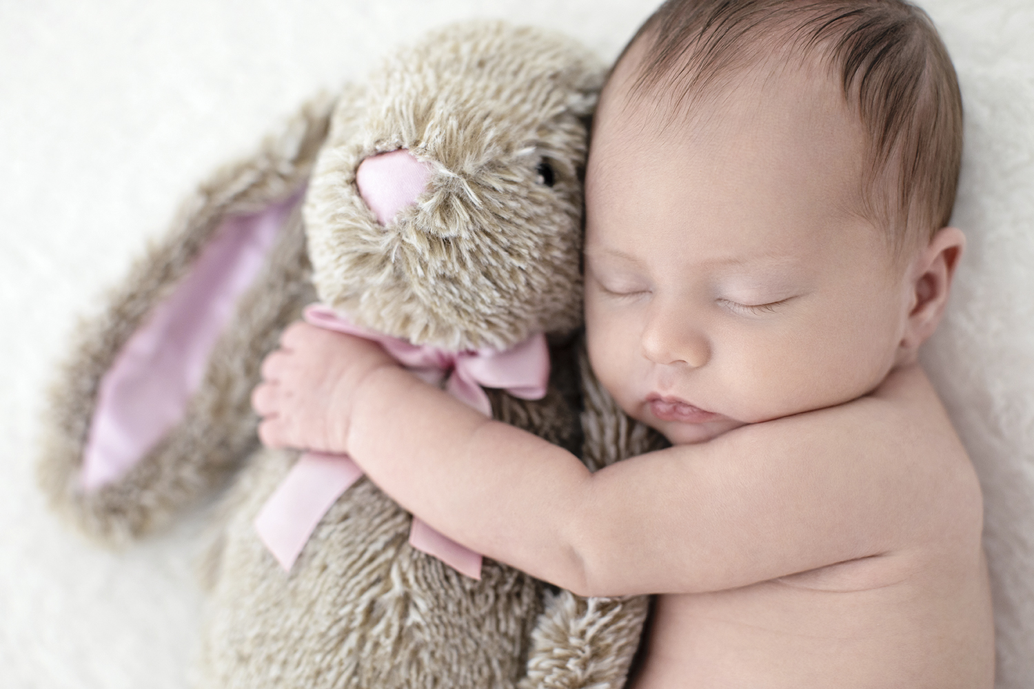 adorable baby holding on to a stuffed animal