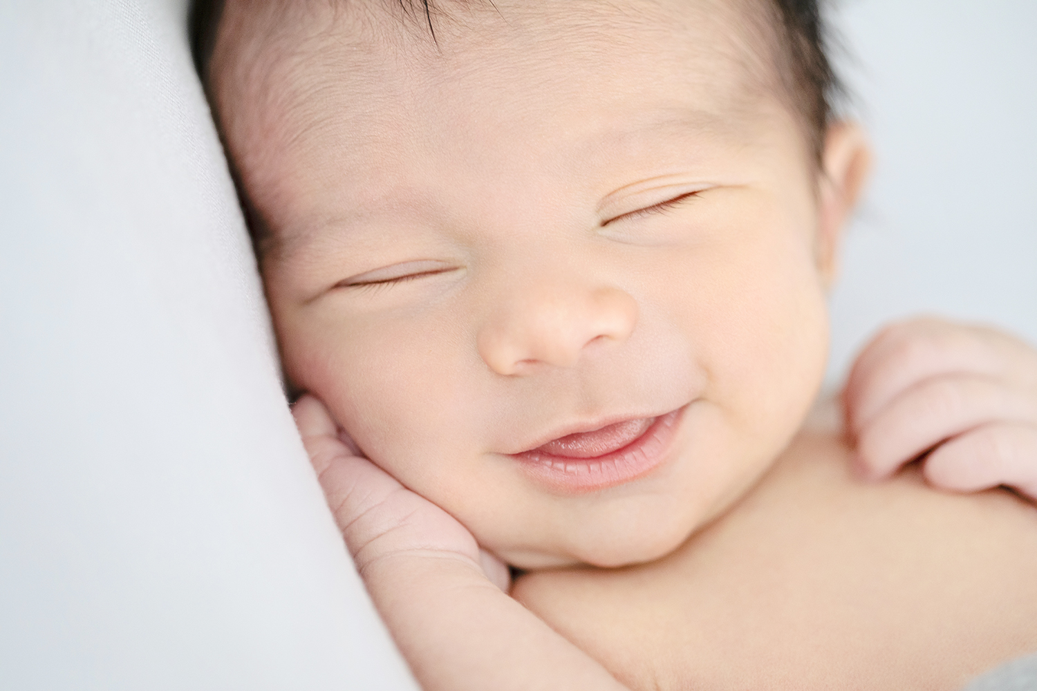 a smiling newborn infant