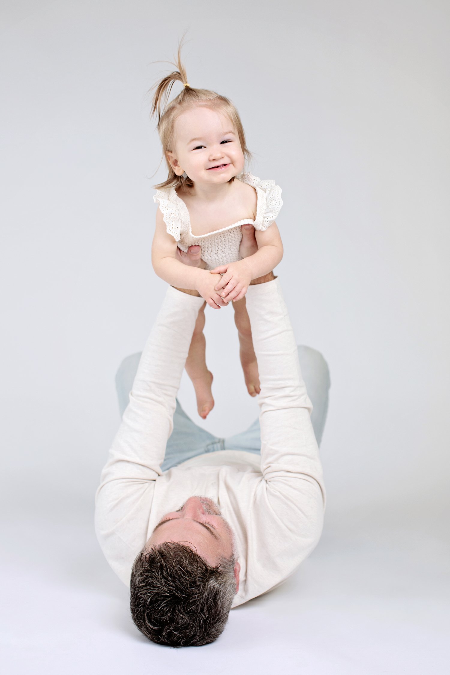 a baby smiling with her dad in a first year photoshoot