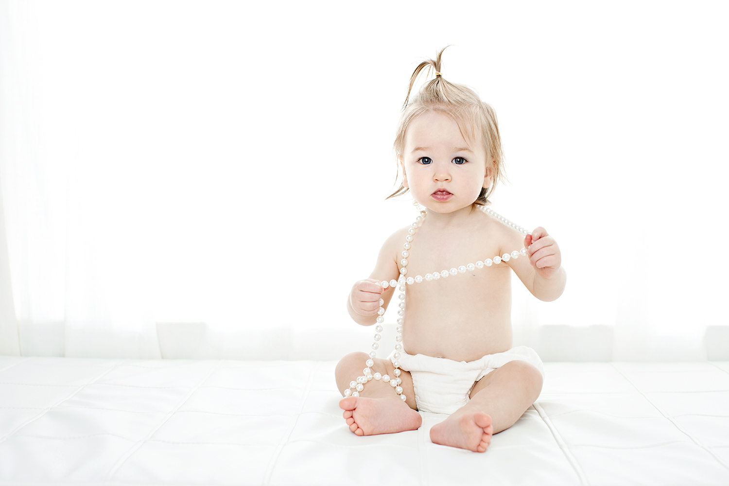 an adorable toddler wearing pearls