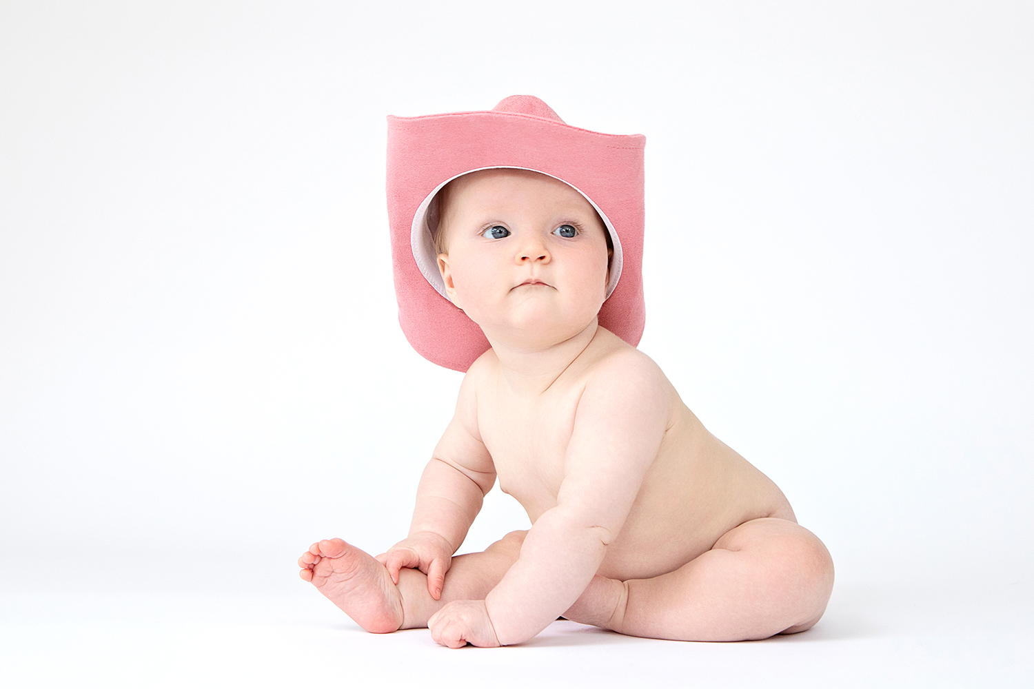a baby wearing a pink cowboy hat