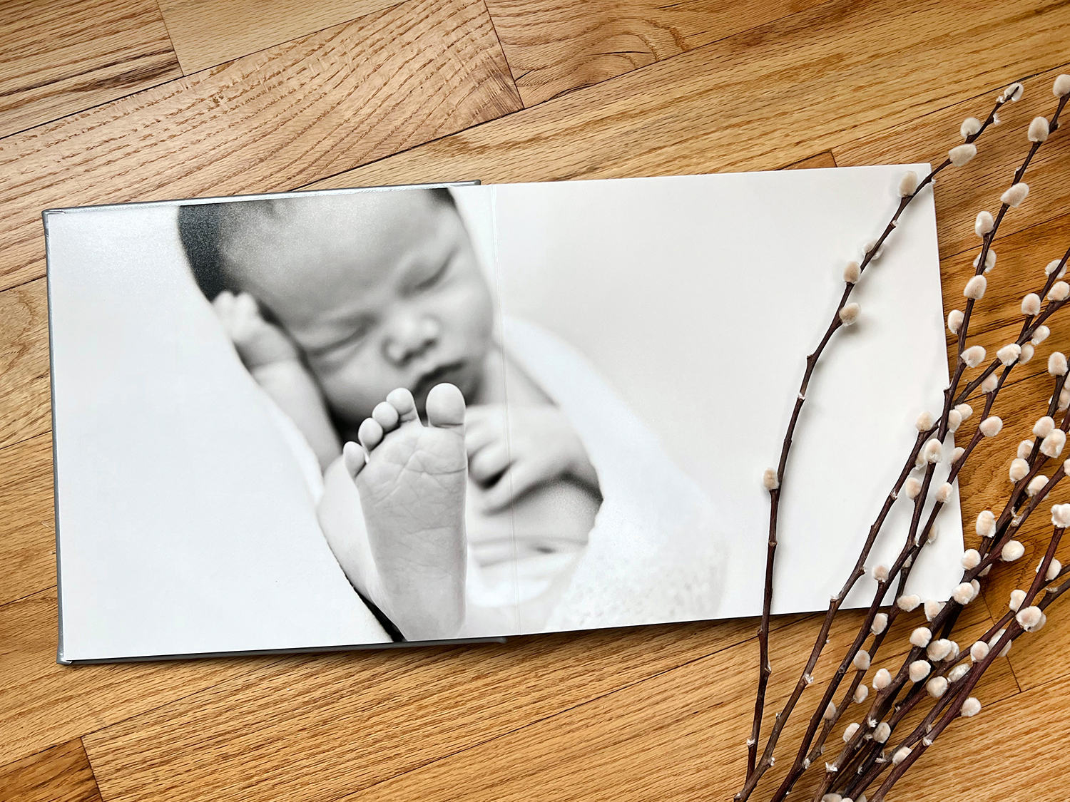 A newborn holds their face in their hands.