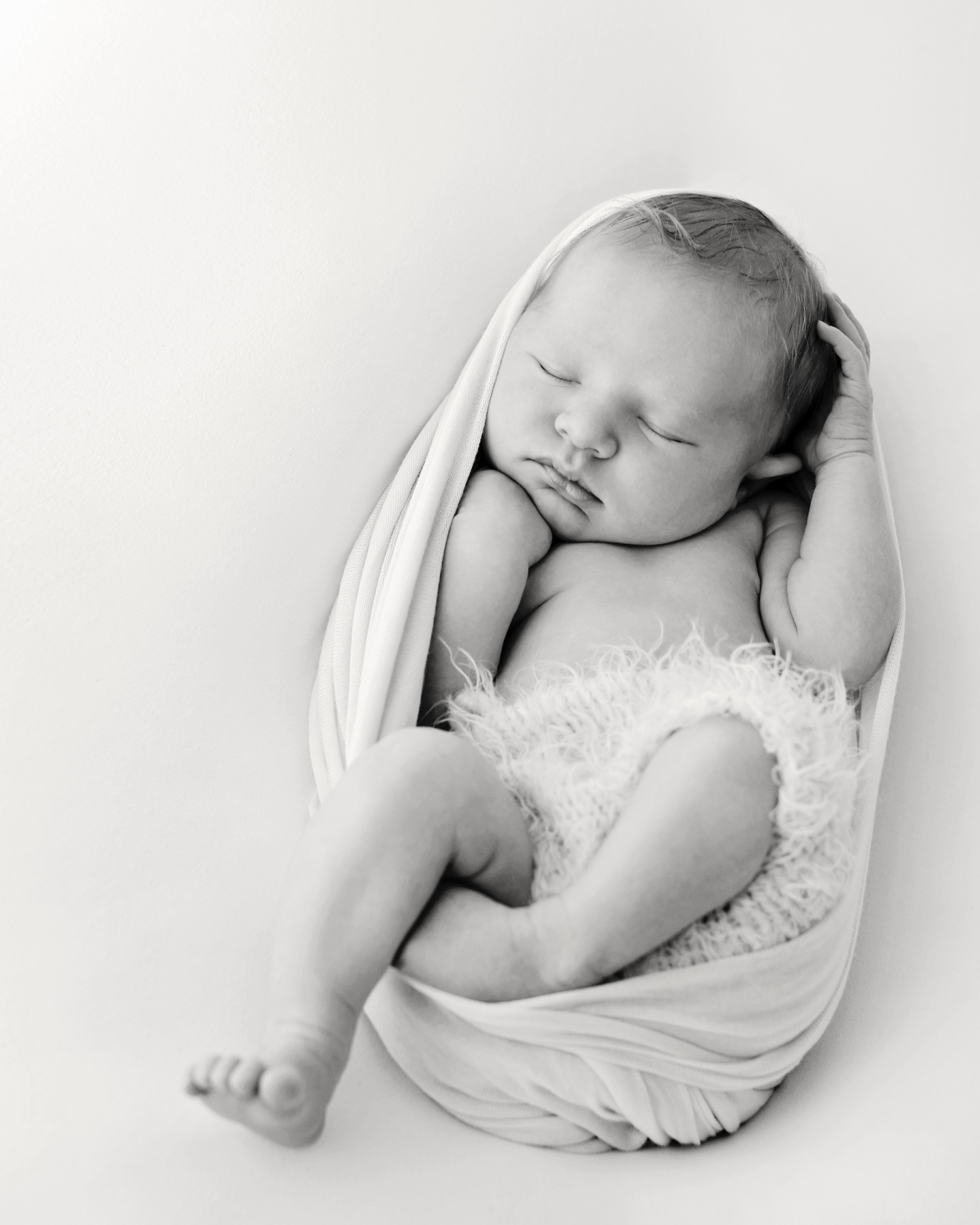 a sleeping baby in black and white at a newborn photoshoot