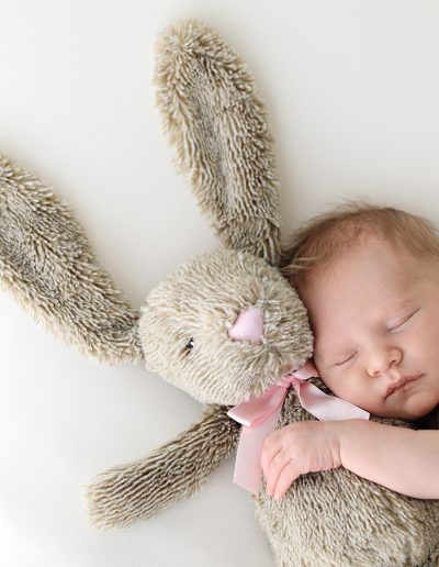 a sleeping baby holding a stuffed animal