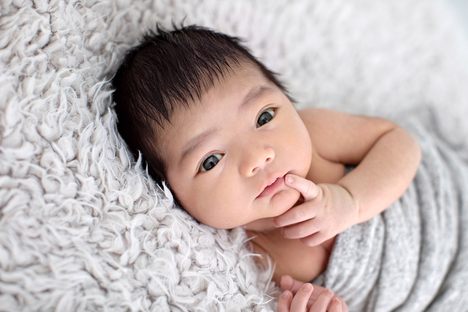 Newborn baby's serene expression during a photoshoot