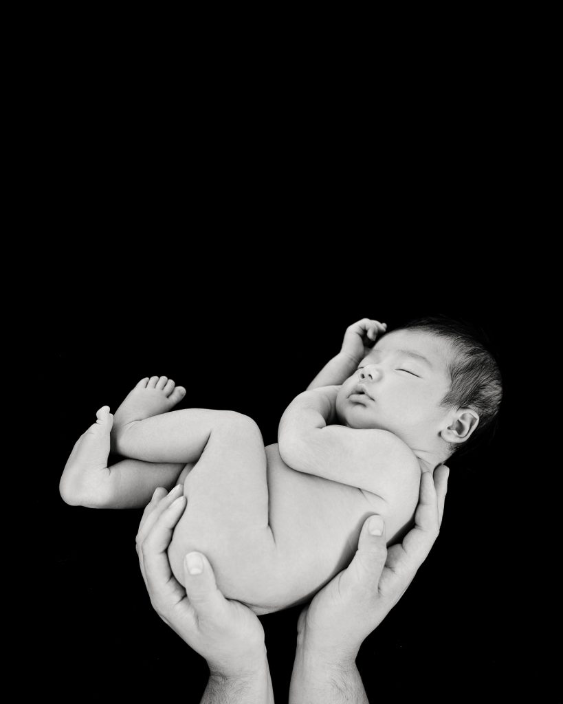 a mother holding her newborn son in black and white photoshoot