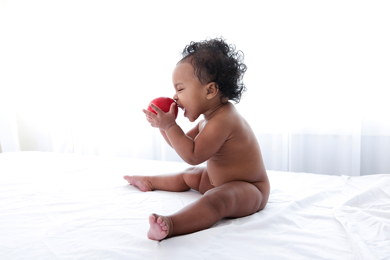 see baby playing with red ball