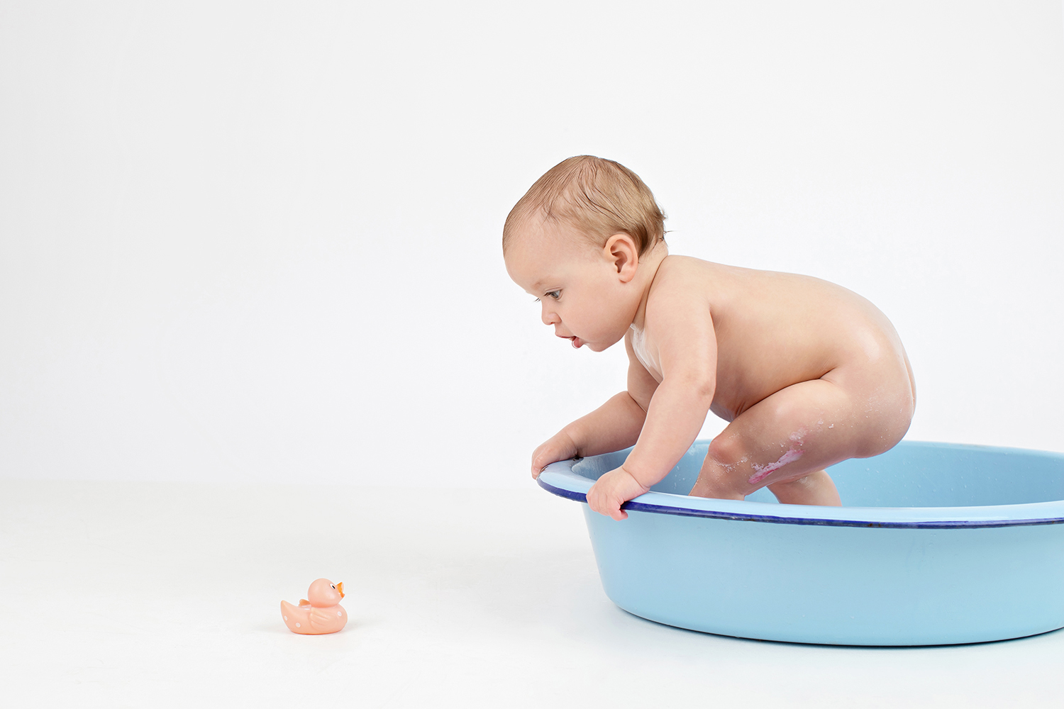 one year baby in blue bath for milestone shoot