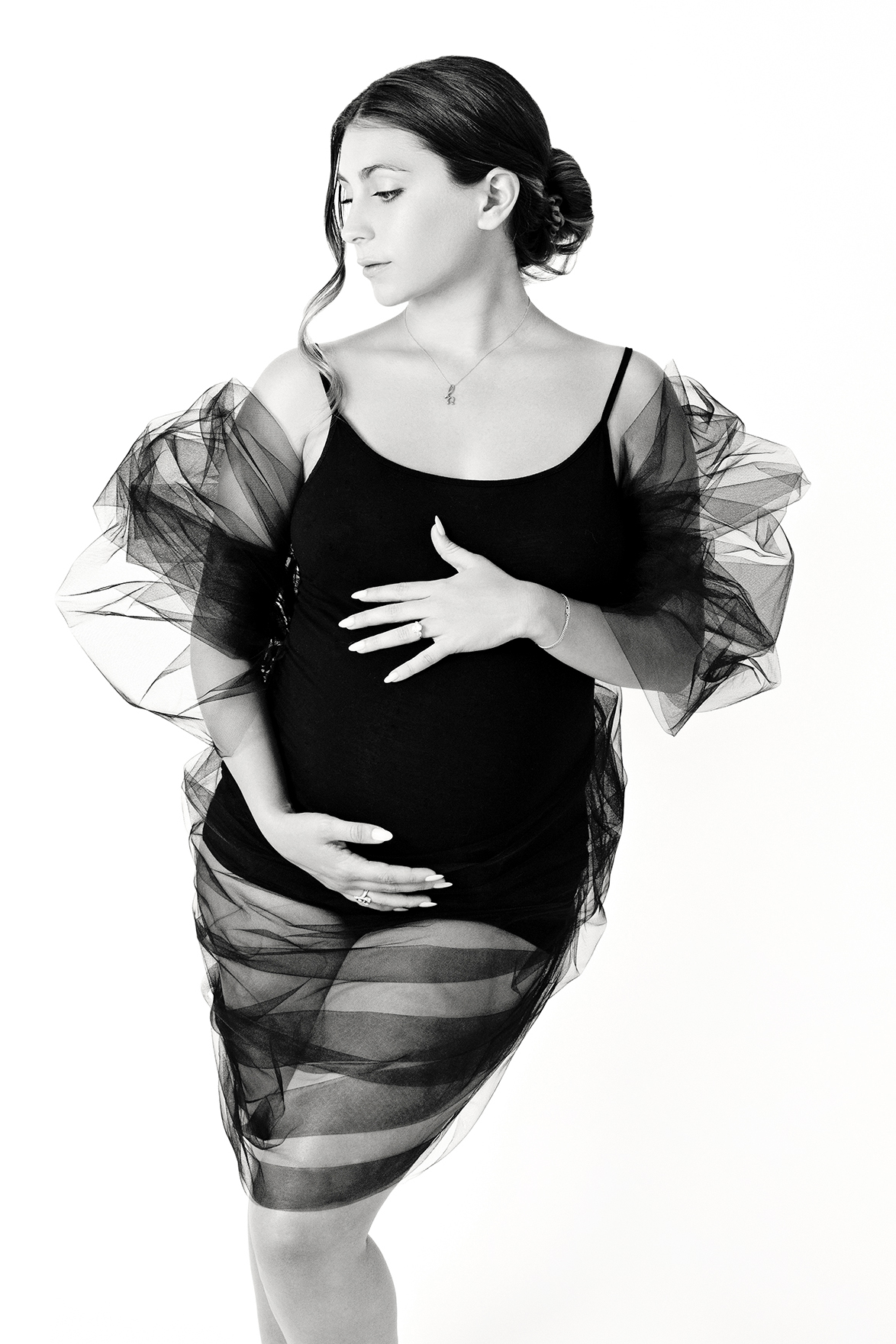 black and white image of pregnant woman in fashion pose in black tulle