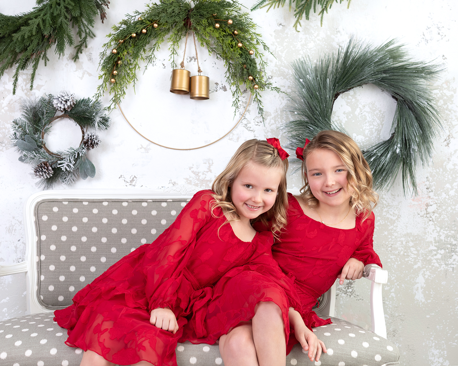 Two young sisters in red Christmas dresses during a Dallas family photoshoot