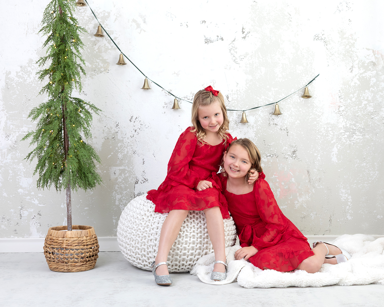 Two young sisters in red Christmas dresses during a Dallas family photoshoot