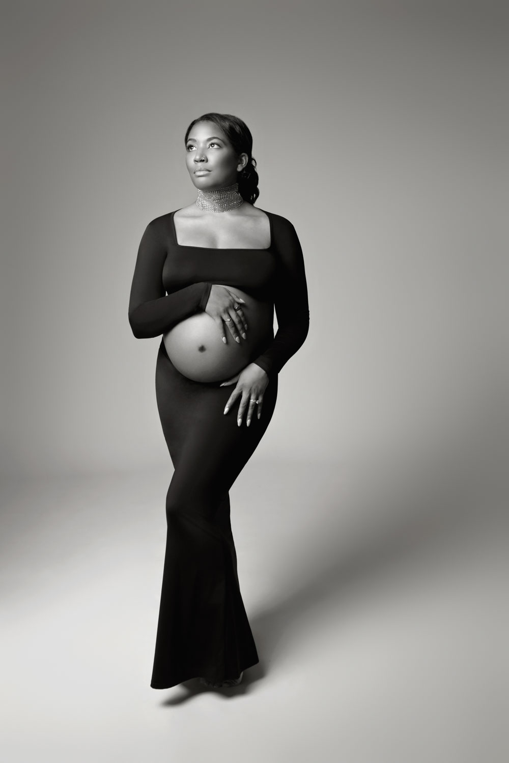 Expecting mother cradling belly during Dallas maternity photography shoot