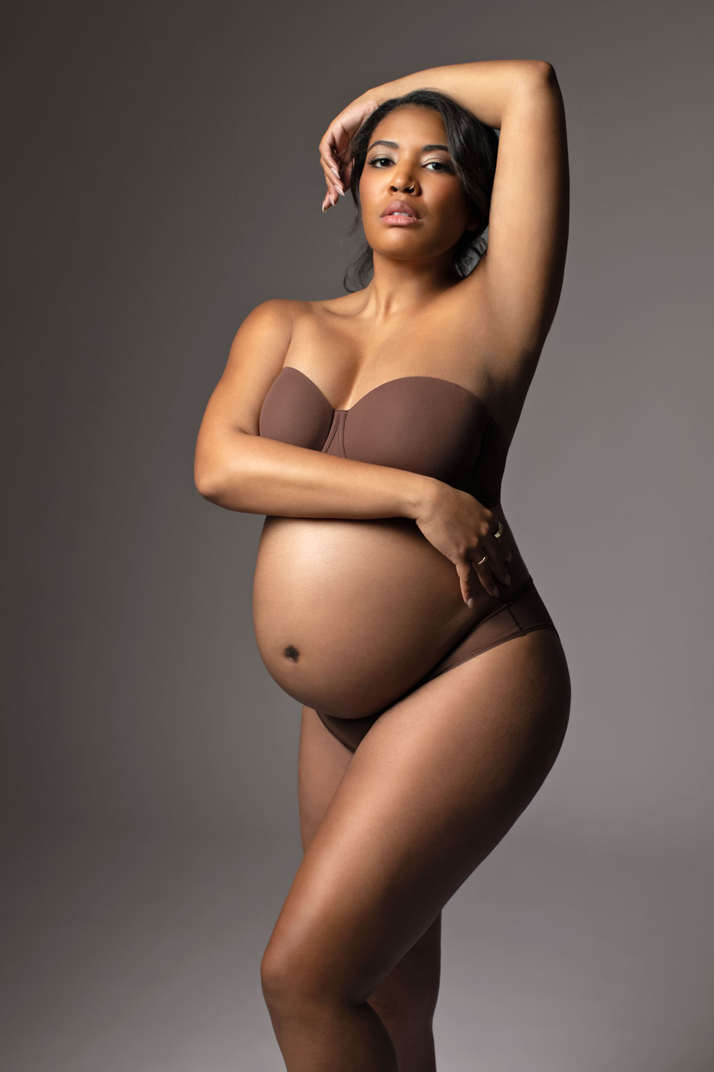 Expecting mother cradling belly during Dallas maternity photography shoot